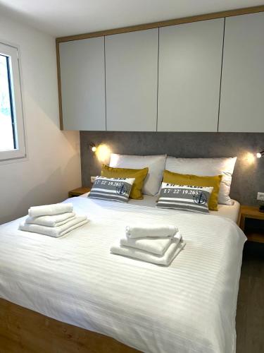 a large white bed with two towels on it at Premium mobile home FJAKA - Oaza Mira Camping Croatia in Drage