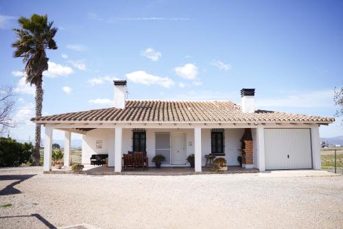 una casa blanca con una palmera delante de ella en La Casilla, en Deltebre