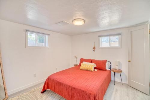 a bedroom with a bed with a red bedspread and two windows at Great Find! 2 BDR, A/C, W/D, Garage in Twin Falls