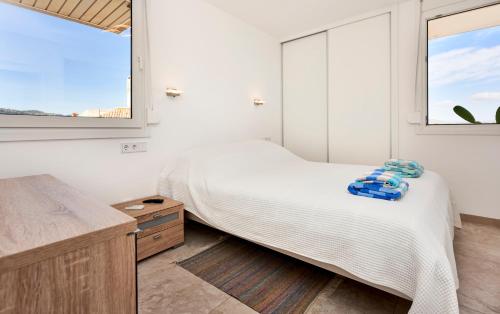 a bedroom with a bed and two windows at Apartamento Torre Bona - Seafront, 10 meters from the beach! in Son Servera