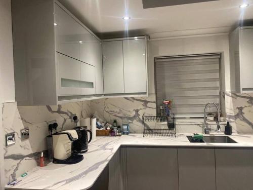 a kitchen with a sink and a counter top at Lovely 3 bedroom house in Borehamwood . in Borehamwood