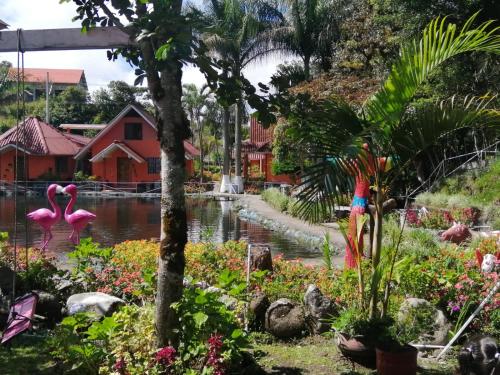 a garden with pink flamingos in a pond at Cabañas Mountain River Lake Inn in Nueva California