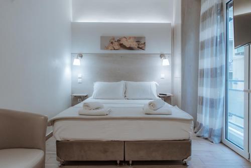 a bedroom with a bed with two towels on it at Acropolis Museum Stylish Apartments in Athens