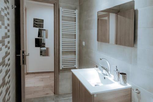 a bathroom with a sink and a mirror and a shower at Acropolis Museum Stylish Apartments in Athens