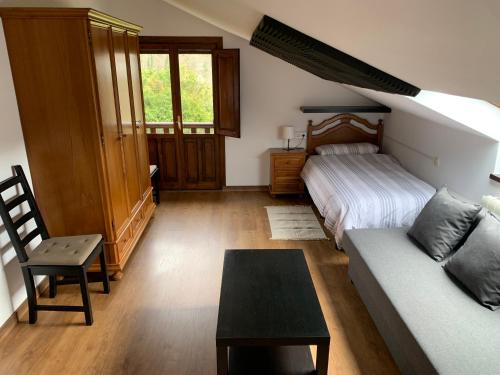 een woonkamer met een bank en een bed bij La Buhardilla De Solavega - VV2530AS in Sevares