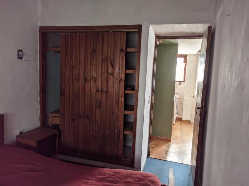 1 dormitorio con armario de madera y cama en departamento en Valeria del mar en Valeria del Mar