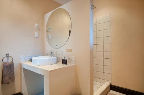 a bathroom with a sink and a mirror at Africa Beach B&B in Port Elizabeth