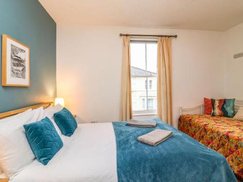 1 dormitorio con 2 camas y ventana en Seaside House, en Weymouth