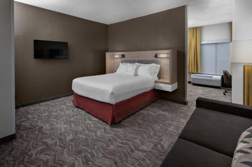 a hotel room with a bed and a couch at SpringHill Suites Houston Hobby Airport in Houston