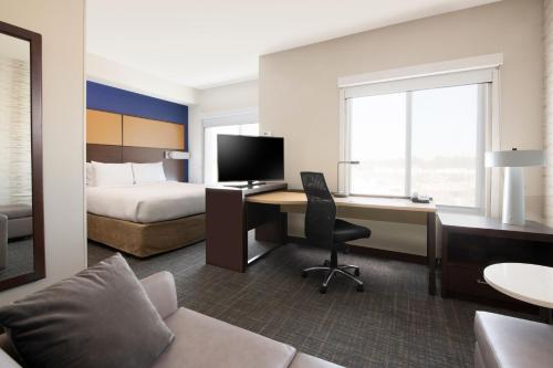 um quarto de hotel com uma cama e uma secretária com um computador em Residence Inn by Marriott Texarkana em Texarkana