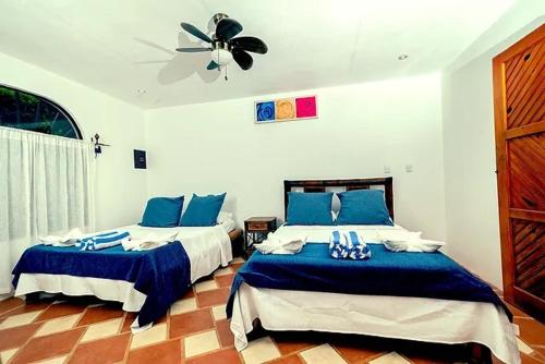 a bedroom with two beds and a ceiling fan at The Scarlet Villas in Ojochal