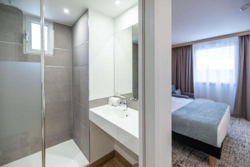 uma casa de banho com um lavatório, um chuveiro e uma cama. em Sure Hotel by Best Western Bordeaux Lac em Bordeaux