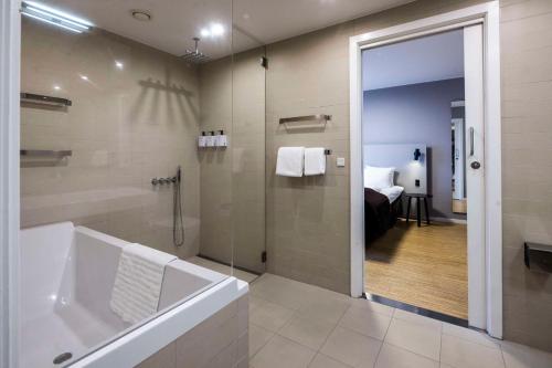 La salle de bains est pourvue d'une baignoire et d'une douche. dans l'établissement Scandic Aarhus City, à Aarhus