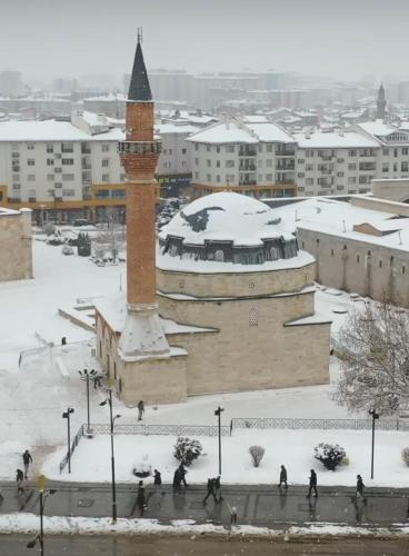 a clock tower in the snow in a city at Özkaya hotel in Sivas