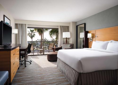 um quarto de hotel com uma cama grande e uma televisão em Sonesta Redondo Beach and Marina em Redondo Beach