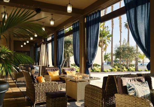 a lobby with chairs and tables and windows at Sonesta Redondo Beach and Marina in Redondo Beach