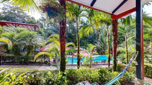 a view of the pool at a resort with palm trees at The Scarlet Villas in Ojochal