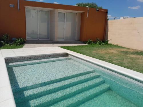una piscina frente a una casa en CASA QUINTA La Donna con DESAYUNO en Villa María