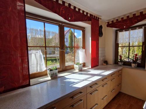 eine große Küche mit roten Vorhängen und einem großen Fenster in der Unterkunft Piece of Greece in Neunburg vorm Wald