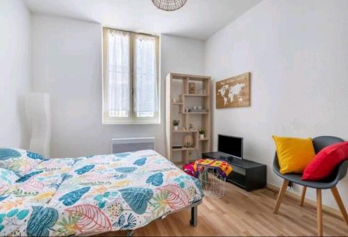 een slaapkamer met een bed, een bureau en een stoel bij Studio très calme 2 pers Centre in Limoges