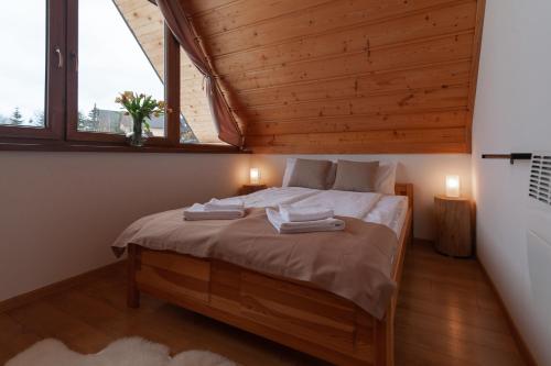 a bedroom with a bed with two towels on it at Kotelnica View in Groń