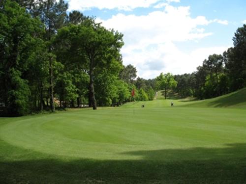 une vue d'un parcours de golf avec un green dans l'établissement Chambres 