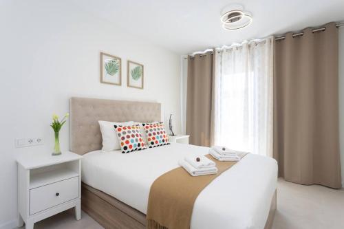 a white bedroom with a large bed and a window at Amazing Brand New Apartment in Santa Cruz in Santa Cruz de Tenerife