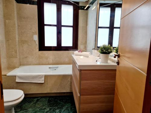 a bathroom with a tub and a sink and a toilet at Glory Home II Catedral in Zamora