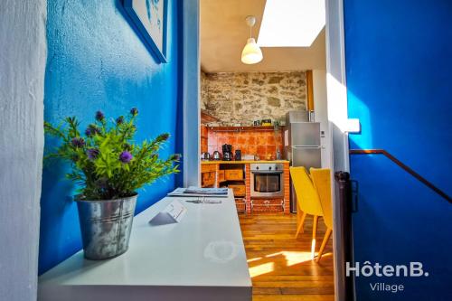 uma cozinha com paredes azuis e uma mesa com um vaso de plantas em La Belle Agapanthe-Iris - Maison de ville à Limoges em Limoges