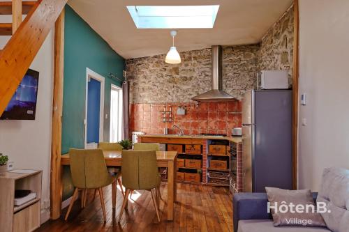 une cuisine et une salle à manger avec une table et un réfrigérateur dans l'établissement La Belle Agapanthe-Iris - Maison de ville à Limoges, à Limoges
