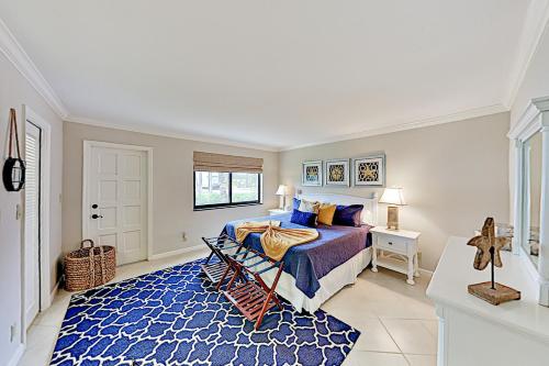 a bedroom with a bed and a blue rug at Shell Shack #9 in Juno Beach