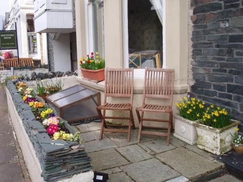 two chairs and some flowers on a patio at Herdwick Guest House in Keswick