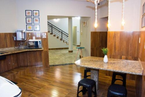 a room with a counter and a table with stools at Fiori Suítes in Goiânia