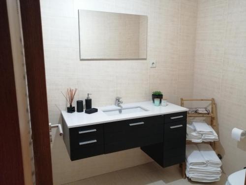 a bathroom with a sink and a mirror at Cantinho da Ana in Viana do Castelo