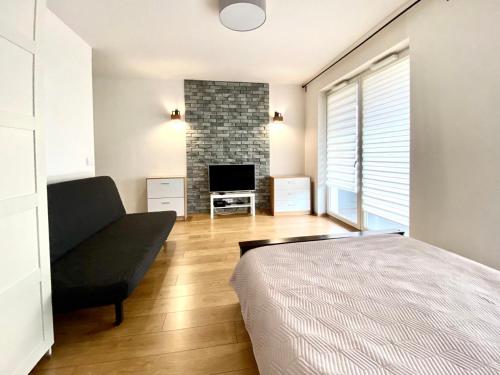 a bedroom with a bed and a couch and a fireplace at K22 Komputerowa Warsaw Apartments in Warsaw