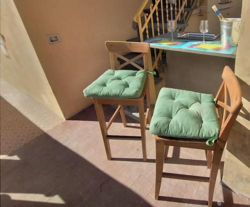 two chairs with green cushions sitting next to a counter at CasarinoLaurino Among Cinque Terre Genova And Portofino in Uscio