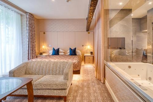 a hotel room with a bed and a bath tub at Ambleside Salutation Hotel & Spa, World Hotel Distinctive in Ambleside