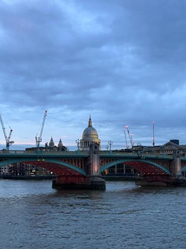 倫敦的住宿－10 minutes to London Bridge x FREE Parking，一座水面上的桥梁,一座建筑的背景
