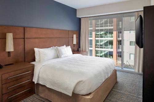 a bedroom with a large bed and a large window at Residence Inn by Marriott Greenville Downtown in Greenville