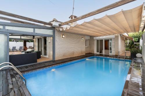 una piscina con pérgola en una casa en "Charm & Cozy 4BR - 3BA with Pool & Barbecue", en Cambrils