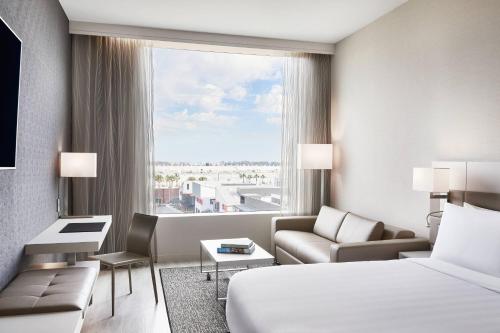 um quarto de hotel com uma cama e uma grande janela em AC Hotel by Marriott Los Angeles South Bay em Los Angeles