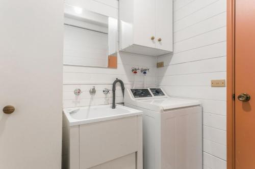uma pequena cozinha branca com um lavatório e um fogão em Arcadia em Wentworth Falls