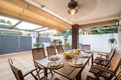 un comedor al aire libre con mesa y sillas en "Charm & Cozy 4BR - 3BA with Pool & Barbecue", en Cambrils