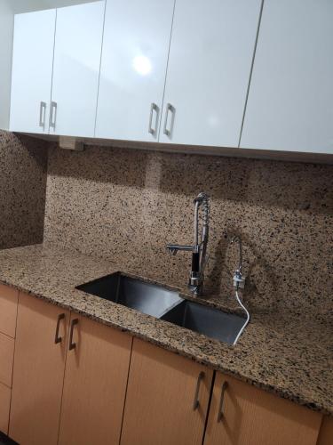 a kitchen counter with a sink and white cabinets at Manhattan Plaza Tower 1 in Manila