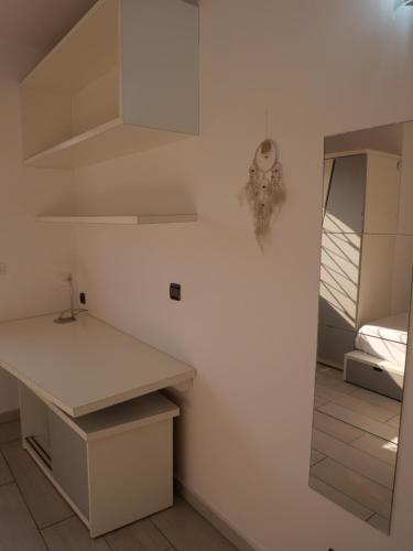 a white kitchen with a counter and a mirror at Résidence Canopée in Libreville