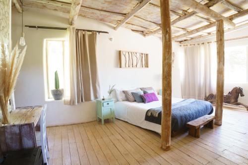 a bedroom with a bed with a wooden ceiling at EcoCasa Sutar in San Pedro de Atacama