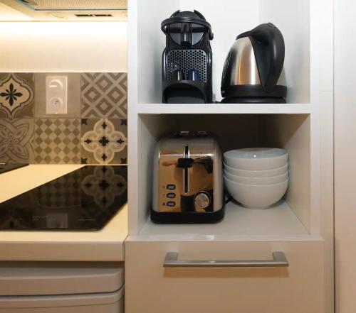 a cupboard with a coffee maker and a toaster at Design Suites Vieux Port in Marseille