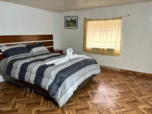 a bedroom with a large bed and a window at Hospedaje Rumiñahui in Ollantaytambo