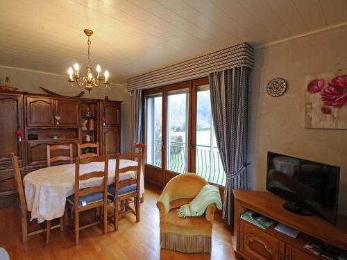 une salle à manger avec une table et une télévision dans l'établissement Gîte spacieux à Saulxures-sur-Moselotte: proche lac, pistes de ski, équipements bébé, animaux acceptés - FR-1-589-145, à Saulxures-sur-Moselotte