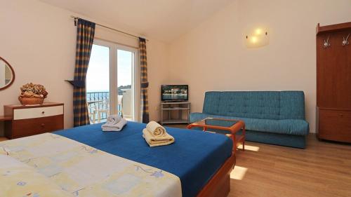 ein Schlafzimmer mit einem blauen Bett und einem Sofa in der Unterkunft Apartments by the sea Drvenik Donja vala, Makarska - 18217 in Drvenik